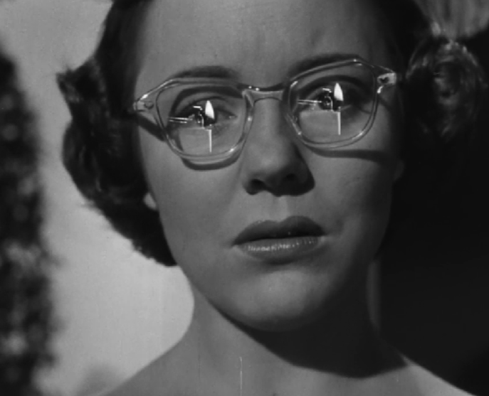 Der Filmzuschauer sieht den Mord durch die Spiegelung der Gläser der brillentragenden Augenzeugin in Alfred Hitchcocks "Der Fremde im Zug" (1951) (© Warner Bros.)